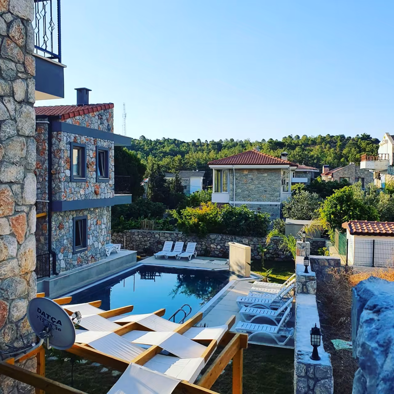 Villa Nora havuzundan doğal taş yapılara bakış